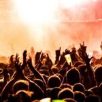people raising their hands on concert
